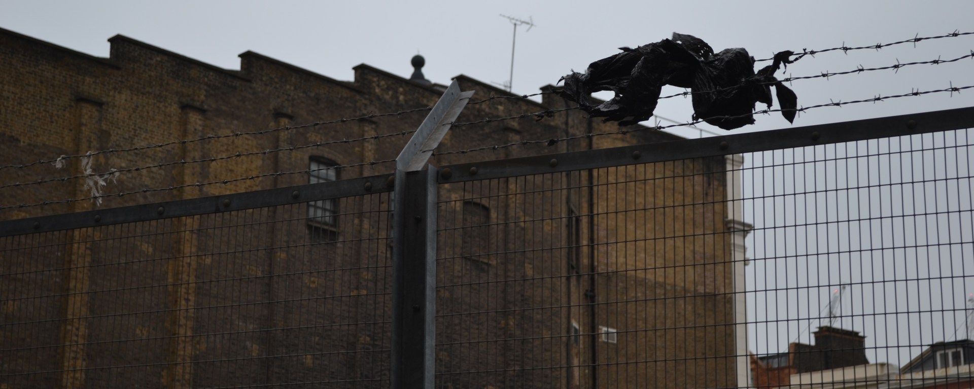 A bin bag stuck on barbed wire, over a railway bridge in King's Cross, London