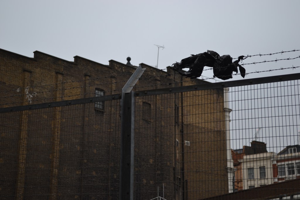 A bin bag stuck on barbed wire, over a railway bridge in King's Cross, London